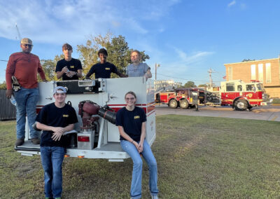 AVFD Junior Cadet members pose on the end of a firetruck ladder.