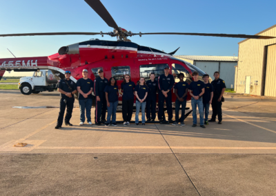Enlistees in the Angleton Volunteer Fire Department Junior Cadet Program posing in front of a helicopter.