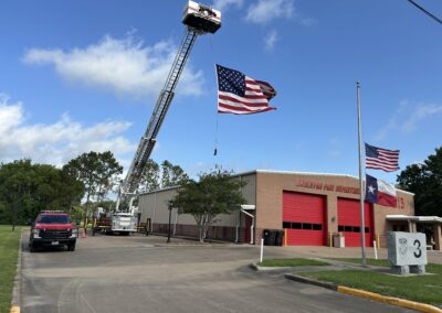 An American flag suspended from an Angleton Volunteer Fire Department firetruck ladder.